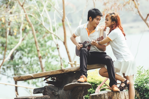 Pareja enamorada de tocar la guitarra en la naturaleza