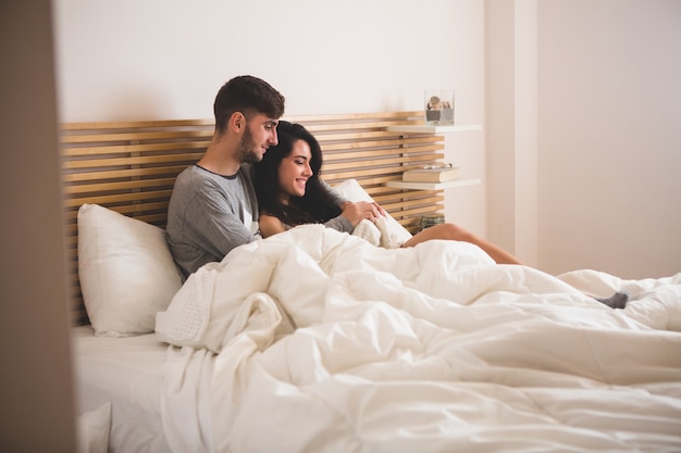 Pareja enamorada tumbada en la cama