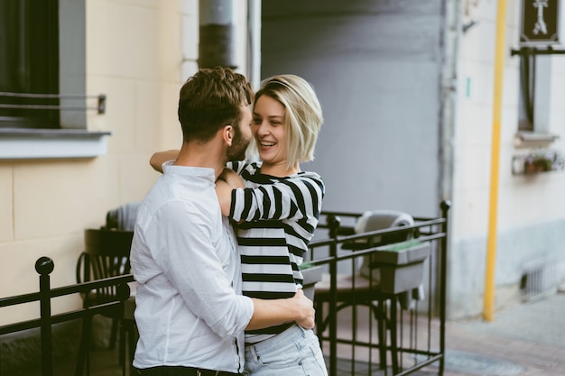 Pareja de enamorados abrazándose en la calle.