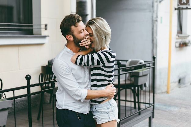 Pareja de enamorados abrazándose en la calle.