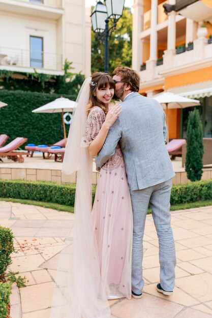 Pareja de enamorados caminando en una villa de lujo mientras celebraba la boda. De longitud completa.