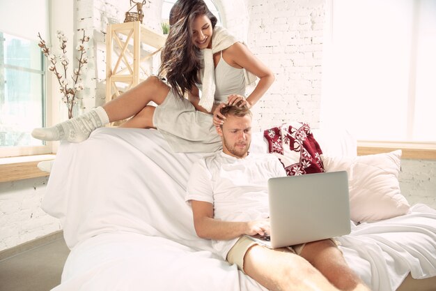 Pareja de enamorados en casa relajándose juntos. Hombre y mujer caucásicos que tienen fin de semana, se ve tierna y feliz