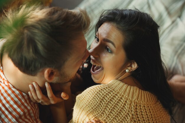 Pareja de enamorados en casa relajándose juntos. Hombre y mujer caucásicos que tienen fin de semana, se ve tierna y feliz