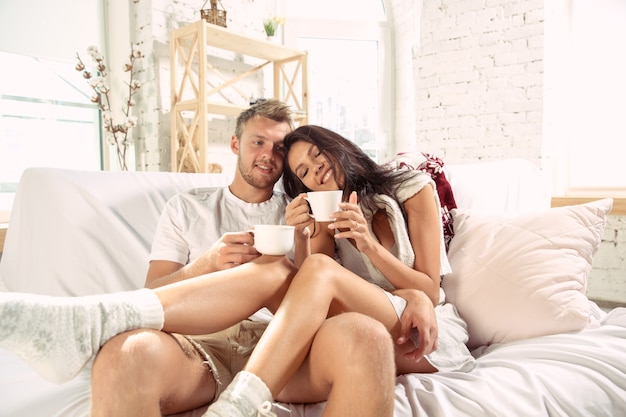 Pareja de enamorados en casa relajándose juntos.