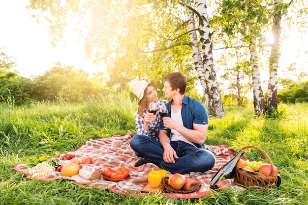 Pareja de enamorados haciendo picnic en el prado