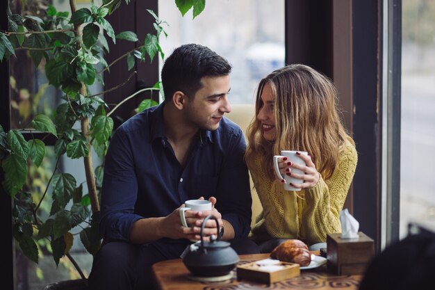 Pareja de enamorados tomando café en la cafetería