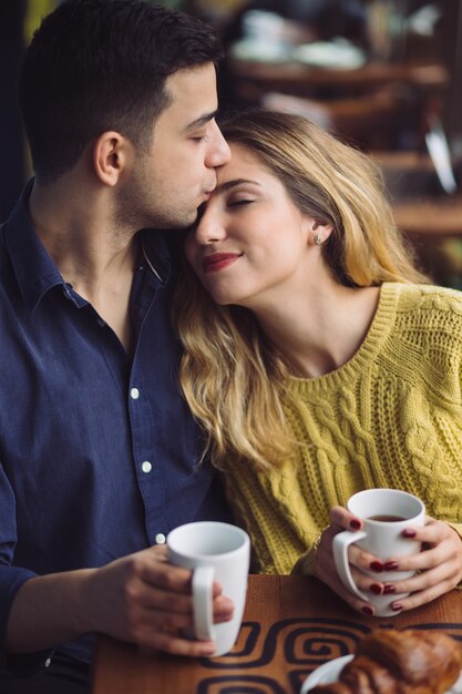 Pareja de enamorados tomando café en la cafetería