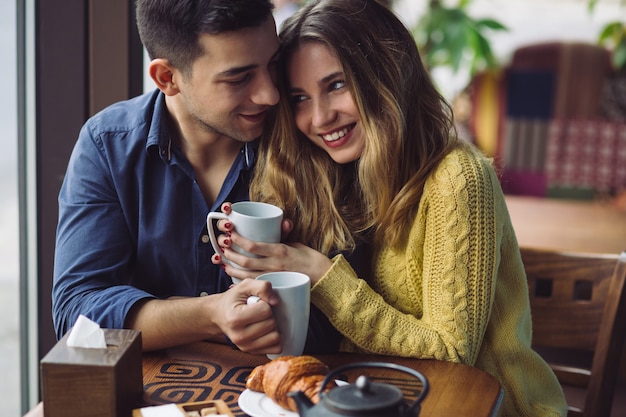 Foto gratuita pareja de enamorados tomando café en la cafetería