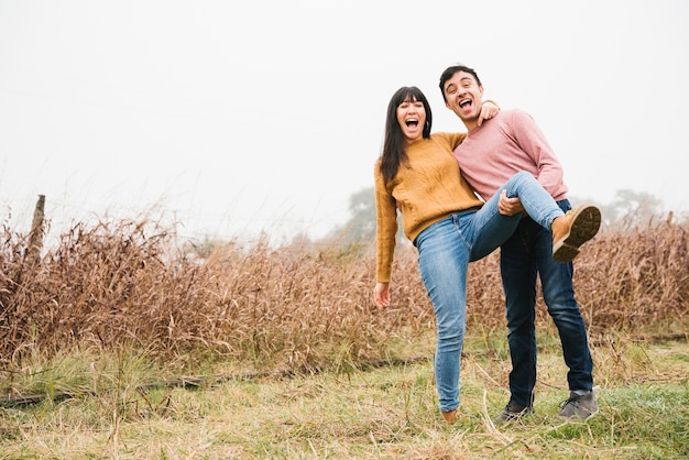 Foto gratuita pareja encantada riendo y engañando en el campo