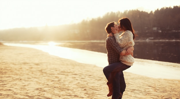 Pareja encantadora besándose al atardecer