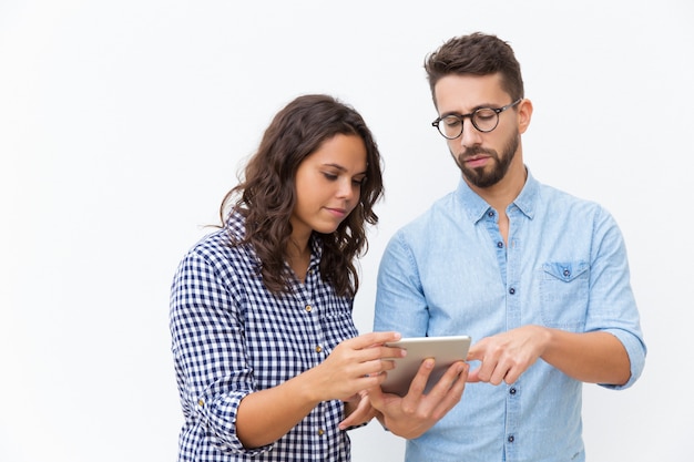 Foto gratuita pareja enfocada con tableta analizando presupuesto familiar