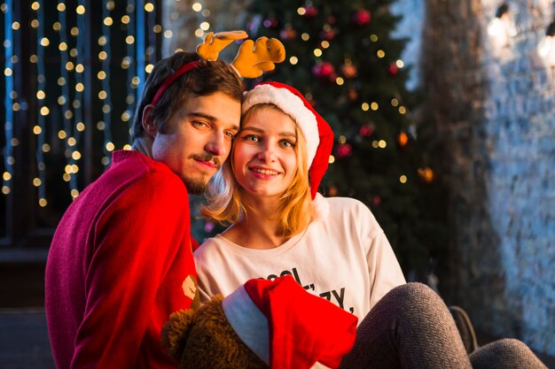 Pareja enfrente de árbol de navidad