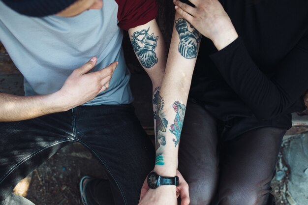 Pareja enseñando sus tatuajes en sus brazos