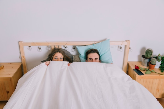 Foto gratuita pareja escondida debajo de la manta