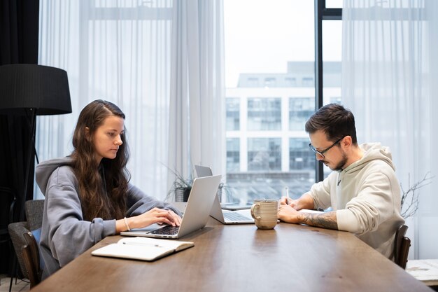 Pareja en el escritorio trabajando juntos desde casa