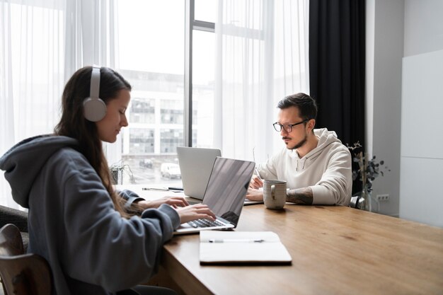 Pareja en el escritorio trabajando juntos desde casa