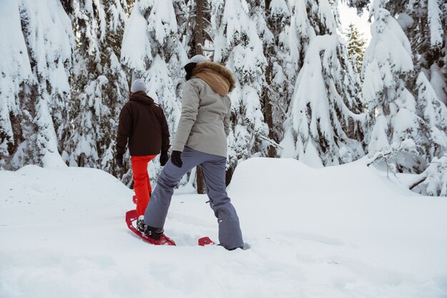 Pareja de esquiadores caminando sobre la montaña nevada