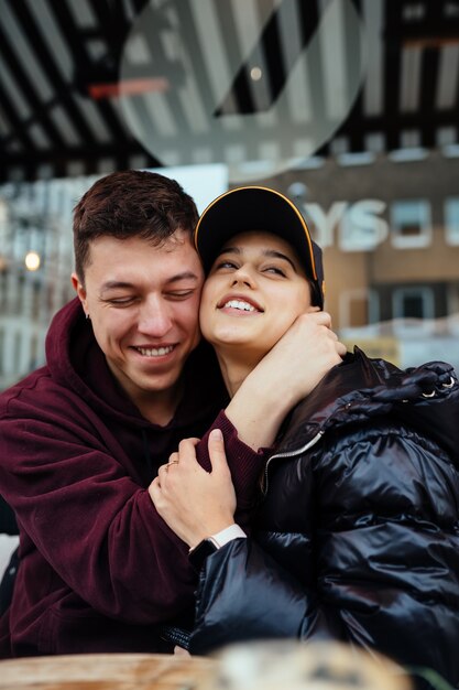 La pareja está abrazándose en una mesa en un café al aire libre