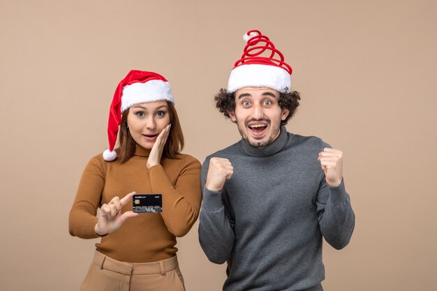 Una pareja está de pie junto al árbol de Navidad.