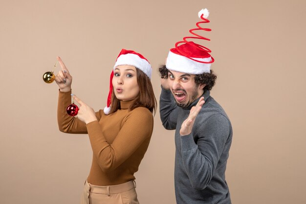 Una pareja está de pie junto al árbol de Navidad.