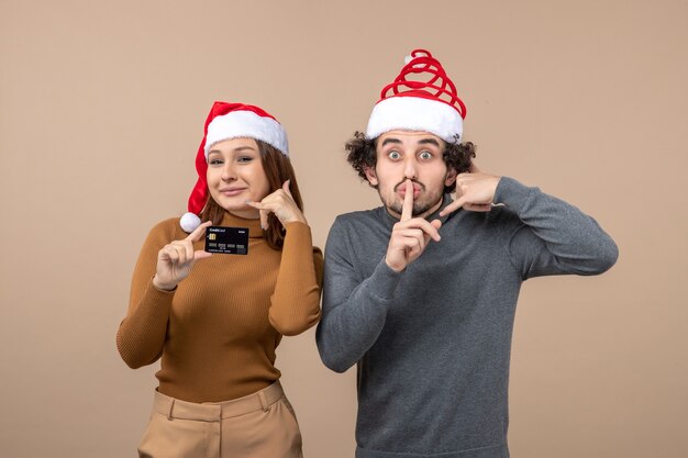 Una pareja está de pie junto al árbol de Navidad.