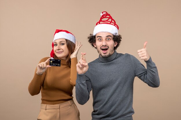 Una pareja está de pie junto al árbol de Navidad.