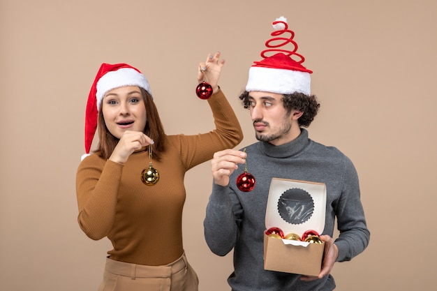 Una pareja está de pie junto al árbol de Navidad.