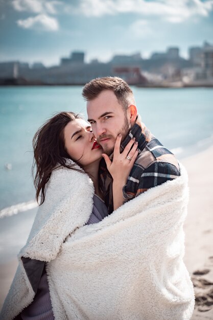 Pareja está de pie en la playa y posando