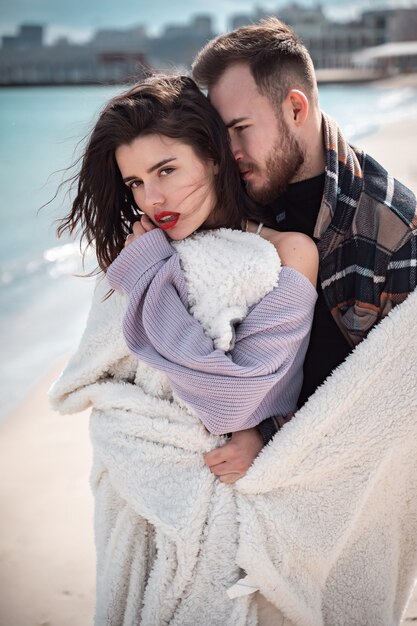 Pareja está de pie en la playa y posando