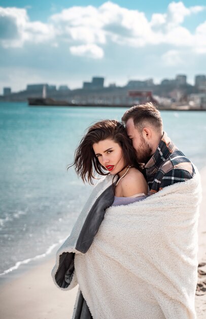 Pareja está de pie en la playa