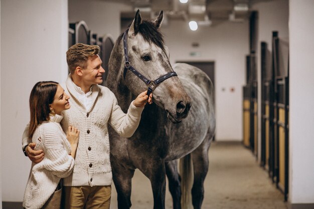 Pareja en establo con caballo.