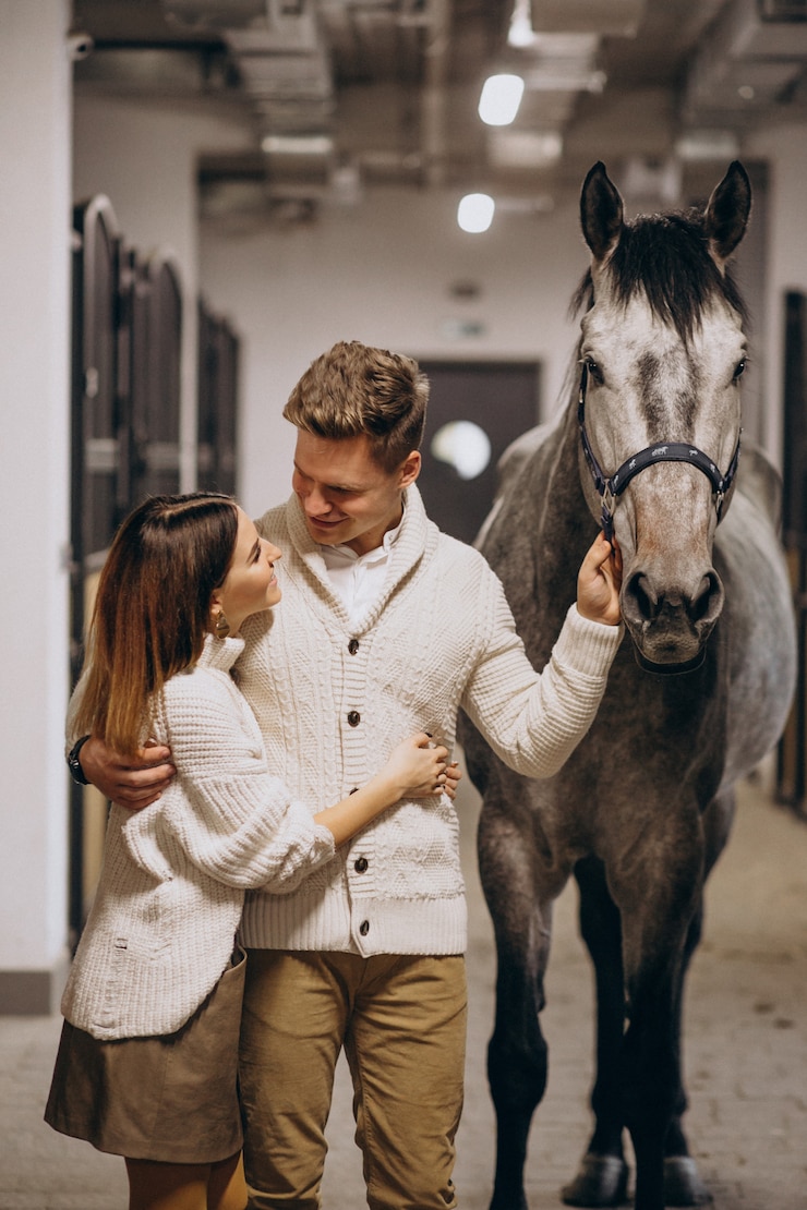 Foto gratuito pareja en establo con caballo.