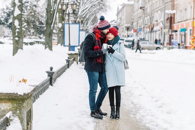 Pareja con estilo con café en la ciudad de invierno