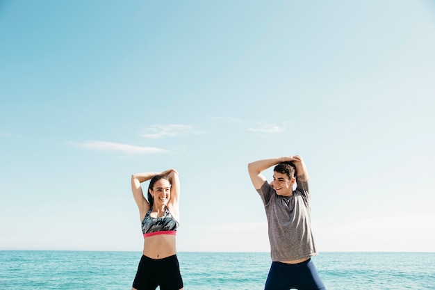 Pareja estirando en la playa