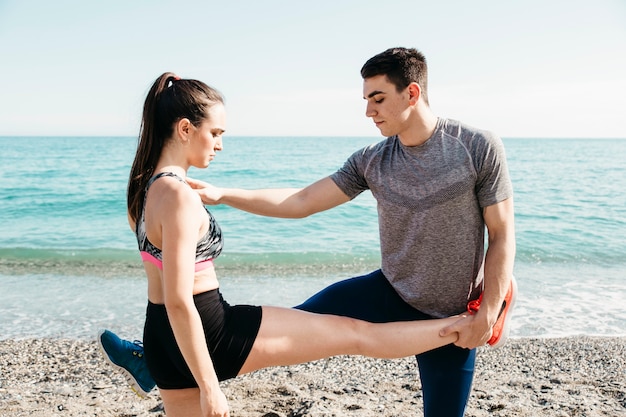 Pareja estirando en la playa