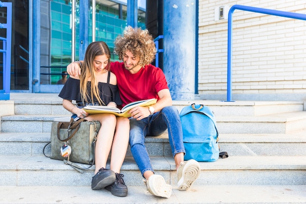 Foto gratuita pareja estudiando en pasos de la universidad