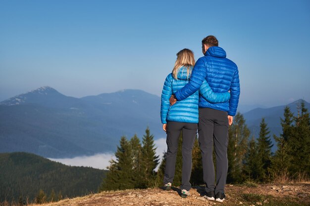 Pareja familiar admirando hermosos paisajes de montaña