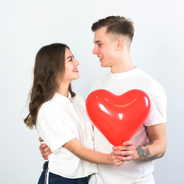 Pareja feliz con abrazos de globo de corazón