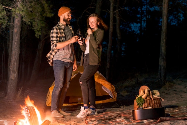 Pareja feliz acampando en la noche