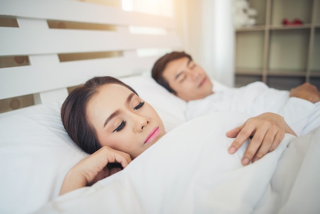 Pareja feliz acostado juntos en la cama