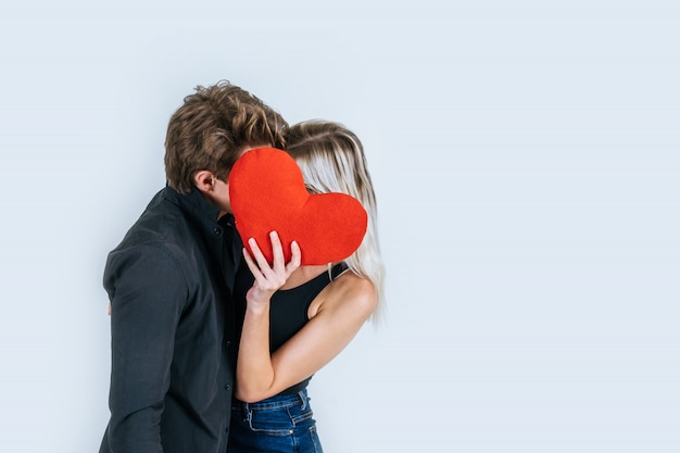 Pareja feliz amando juntos sosteniendo un corazón rojo