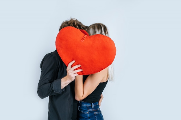 Pareja feliz amando juntos sosteniendo un corazón rojo