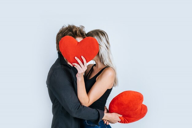 Pareja feliz amando juntos sosteniendo un corazón rojo