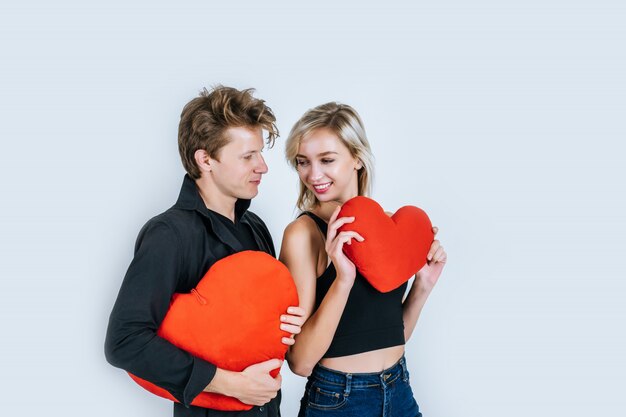 Pareja feliz amando juntos sosteniendo un corazón rojo