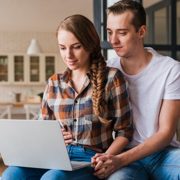 Pareja feliz en el amor abrazando y mirando a la computadora