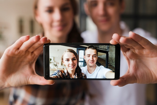 Pareja feliz en el amor haciendo selfie juntos