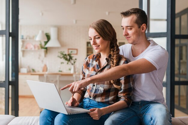 Pareja feliz en el amor mirando portátil