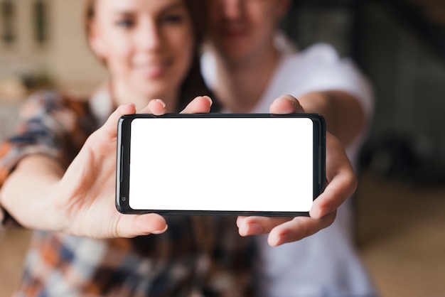 Pareja feliz en el amor que muestra la pantalla del teléfono inteligente