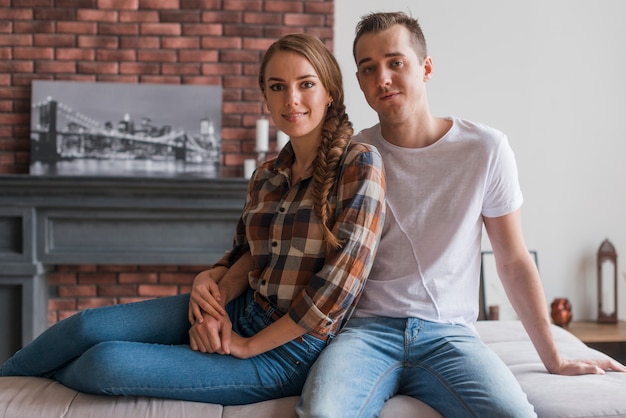 Foto gratuita pareja feliz en el amor sentados juntos en casa