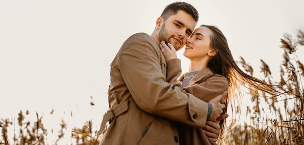 Pareja feliz de ángulo bajo en la naturaleza